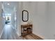 Entryway with wood floors, decorative table and mirror, and an open view of the living space at 9008 Waxwing Way, Parrish, FL 34219