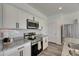 Stylish kitchen featuring stainless steel appliances, white cabinets, and granite countertops at 9008 Waxwing Way, Parrish, FL 34219
