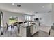 Modern kitchen with a granite island, stainless steel appliances, and an open view to living room at 9008 Waxwing Way, Parrish, FL 34219