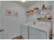 Well-lit laundry room includes a modern washer and dryer set and ample shelving storage at 9008 Waxwing Way, Parrish, FL 34219