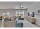 Bright living room boasts large windows, modern ceiling fan, and comfortable sectional sofa at 9008 Waxwing Way, Parrish, FL 34219