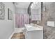 Modern bathroom featuring a marble countertop vanity, decorative shower curtain, and stylish tile accent wall at 9151 Melody Cir, Port Charlotte, FL 33981