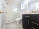 A renovated bathroom with a modern vanity, glass shower doors, and gold fixtures at 9308 Pinero St, Spring Hill, FL 34608