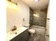 A renovated bathroom featuring a tub-shower combination with brown marble tiling and gold hardware at 9308 Pinero St, Spring Hill, FL 34608
