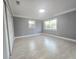 A spacious bedroom with neutral paint, tile floors, two large windows, and a sliding-door closet at 9308 Pinero St, Spring Hill, FL 34608