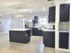 Bright kitchen boasts navy cabinets, stainless steel appliances, and a center island with white countertops at 9308 Pinero St, Spring Hill, FL 34608