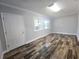A spacious living room with dark wood-look tile flooring, neutral paint, and natural light at 9308 Pinero St, Spring Hill, FL 34608