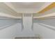 Walk-in closet with white walls, shelving, and hanging rods for optimal storage at 9945 47Th N Ave # 101, St Petersburg, FL 33708