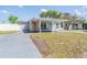 Home exterior featuring a covered entrance, complemented by a lush lawn and drive at 10309 108Th Ave, Largo, FL 33773