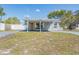 View of house with covered porch, gray paint, and green grass at 10309 108Th Ave, Largo, FL 33773