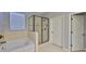 Well-lit bathroom features a separate tub and shower with glass door and neutral tile at 10315 Riverdale Rise Dr, Riverview, FL 33578
