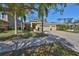 Inviting front exterior features a well-manicured lawn, two-car garage, and palm trees at 10315 Riverdale Rise Dr, Riverview, FL 33578