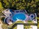 Aerial shot of a community pool showcasing a spa, lounge chairs, and lush greenery at 1076 Paseo Del Rio Ne, St Petersburg, FL 33702