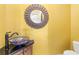 Bathroom features a colorful bowl sink and decorative mirror on mustard-colored wall at 1076 Paseo Del Rio Ne, St Petersburg, FL 33702