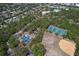 Aerial view showcasing tennis and basketball courts near homes and a pool at 10928 N 15Th St, Tampa, FL 33612