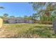 A spacious fenced backyard wraps around a single story home, complete with a patio and greenery at 10928 N 15Th St, Tampa, FL 33612