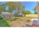 View of the backyard featuring grass, trees, and a privacy fence at 10928 N 15Th St, Tampa, FL 33612