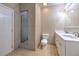 Bathroom featuring a dual vanity, a shower with a glass door, and neutral tile at 10928 N 15Th St, Tampa, FL 33612