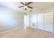 A bedroom with neutral paint, tile flooring, a ceiling fan, closet doors, and natural light at 10928 N 15Th St, Tampa, FL 33612