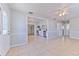 A bright living room featuring neutral paint, tile flooring, and an open view to the kitchen at 10928 N 15Th St, Tampa, FL 33612