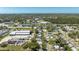 An aerial shot showcases a neighborhood near commercial areas, lakes, and a verdant green space under a clear sky at 11114 Freedom Way, Seminole, FL 33772