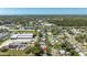 An aerial shot showcases a neighborhood near commercial areas, lakes, and a verdant green space under a clear sky at 11114 Freedom Way, Seminole, FL 33772