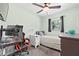 Bedroom with a ceiling fan, gaming setup, desk, and window allowing natural light at 11114 Freedom Way, Seminole, FL 33772