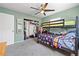 This bedroom features a bunk bed, closet with storage, and modern carpeting with green colored walls at 11114 Freedom Way, Seminole, FL 33772