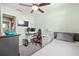 Bedroom featuring a gaming setup, television, ceiling fan, and a doorway to another room at 11114 Freedom Way, Seminole, FL 33772