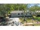 Charming single-story home with a well-maintained lawn, mature trees, and inviting curb appeal on a bright day at 11114 Freedom Way, Seminole, FL 33772