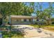 A one-story home featuring a well-manicured front yard and mature trees at 11114 Freedom Way, Seminole, FL 33772