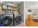 This laundry room features modern Samsung washer and dryer units, with shelving for storage, connecting to the bedroom at 11114 Freedom Way, Seminole, FL 33772