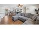 Open-concept living room featuring wood floors and a comfortable gray sectional couch with decorative pillows at 11114 Freedom Way, Seminole, FL 33772