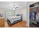 Comfortable main bedroom with a ceiling fan, natural light, wood floors, and a walk-in closet at 11114 Freedom Way, Seminole, FL 33772