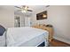 Well-lit main bedroom with wood floors, a ceiling fan, dresser and an ensuite bathroom at 11114 Freedom Way, Seminole, FL 33772