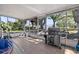 View of an outdoor screened porch featuring a grill and chairs with a backyard view at 11114 Freedom Way, Seminole, FL 33772