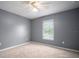 Neutral bedroom features a large window and neutral carpeting, filled with natural light at 11310 Callaway Pond Dr, Riverview, FL 33579