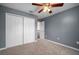 Bedroom features carpet flooring, a ceiling fan and a closet with bifold doors at 11310 Callaway Pond Dr, Riverview, FL 33579
