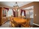 Dining room boasts wood table set, rustic light fixture, large windows and beautiful accent cabinet at 11310 Callaway Pond Dr, Riverview, FL 33579