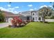 Attractive two-story home with vibrant landscaping, lush green grass, and healthy mature palm tree at 11310 Callaway Pond Dr, Riverview, FL 33579