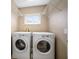 Bright laundry room featuring a side-by-side washer and dryer, shelves for storage and a window at 11310 Callaway Pond Dr, Riverview, FL 33579