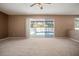 Spacious carpeted living room with a ceiling fan and sliding glass doors to the outdoor pool area at 11310 Callaway Pond Dr, Riverview, FL 33579