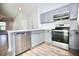 Kitchen featuring stainless steel appliances, gray cabinets, and an open view to the living area at 11618 Colony Lake Dr, Tampa, FL 33635