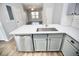 Modern kitchen island featuring stainless steel appliances, quartz countertops and grey cabinets at 11618 Colony Lake Dr, Tampa, FL 33635