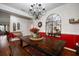 Charming dining room featuring a large wooden table, decorative mirror, and elegant chandelier at 12335 Silton Peace Dr, Riverview, FL 33579