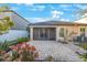 This home features a brick back patio with well-manicured landscaping, flowering bushes, and a screened lanai at 12523 Longstone Ct, New Port Richey, FL 34655