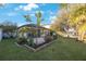 An expansive backyard with a brick patio and an array of different trees and plants at 12523 Longstone Ct, New Port Richey, FL 34655
