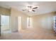 Spacious carpeted bedroom with ceiling fan, walk-in closet, and ample natural light at 12523 Longstone Ct, New Port Richey, FL 34655