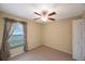 Bedroom with carpet, ceiling fan, and window with curtains at 12523 Longstone Ct, New Port Richey, FL 34655