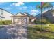 Charming single-story home featuring a brick driveway, manicured lawn, and an attached two-car garage at 12523 Longstone Ct, New Port Richey, FL 34655